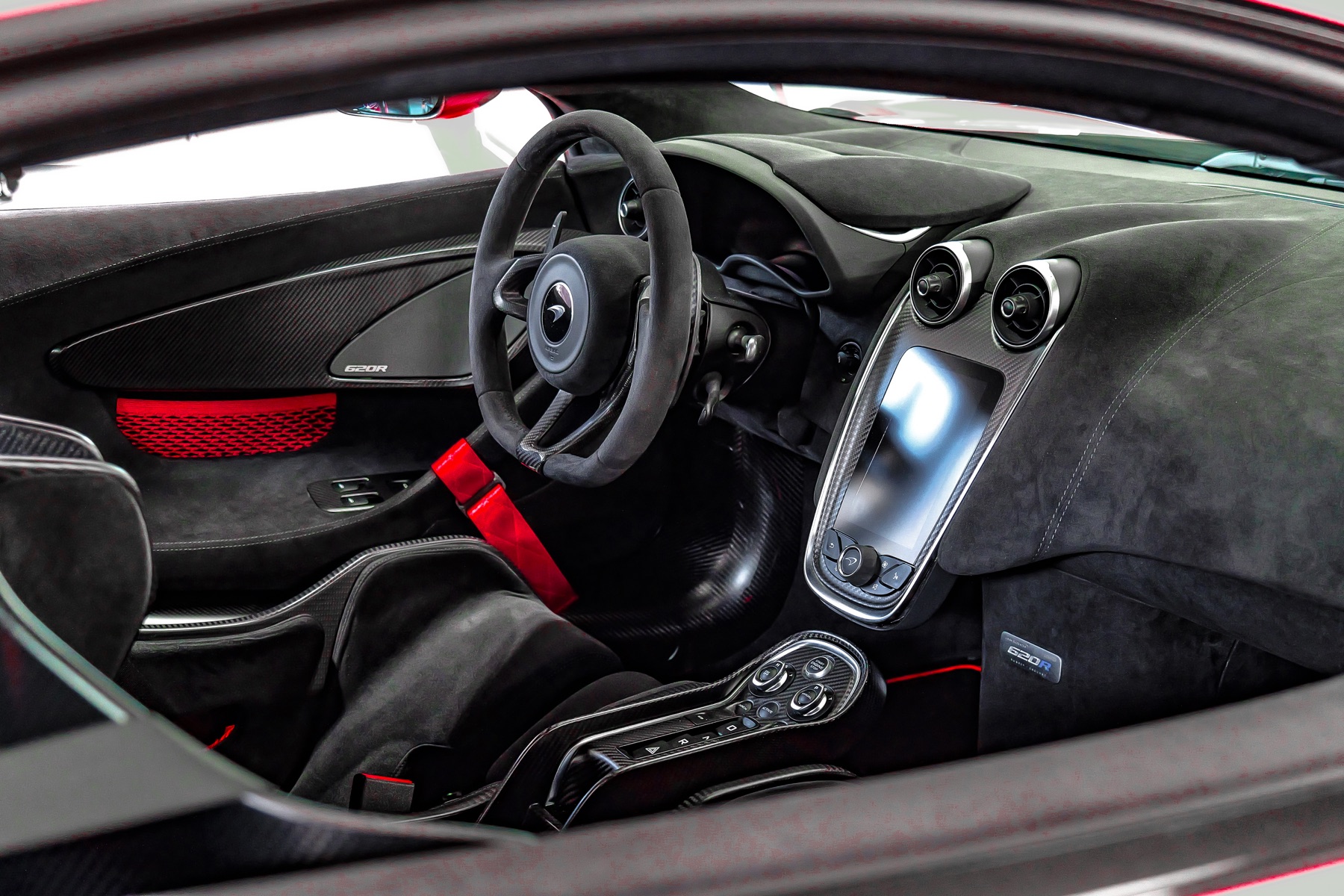 McLaren 620R cockpit with carbon trim and red harness